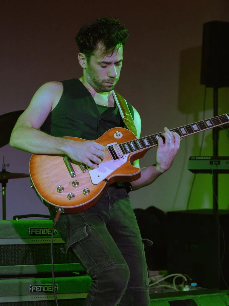 Five-piece punk band mid-performance under red stage lights