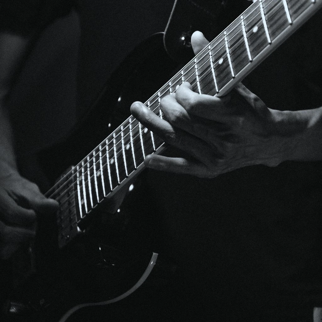 Black-and-white concert photo of a band mid-performance