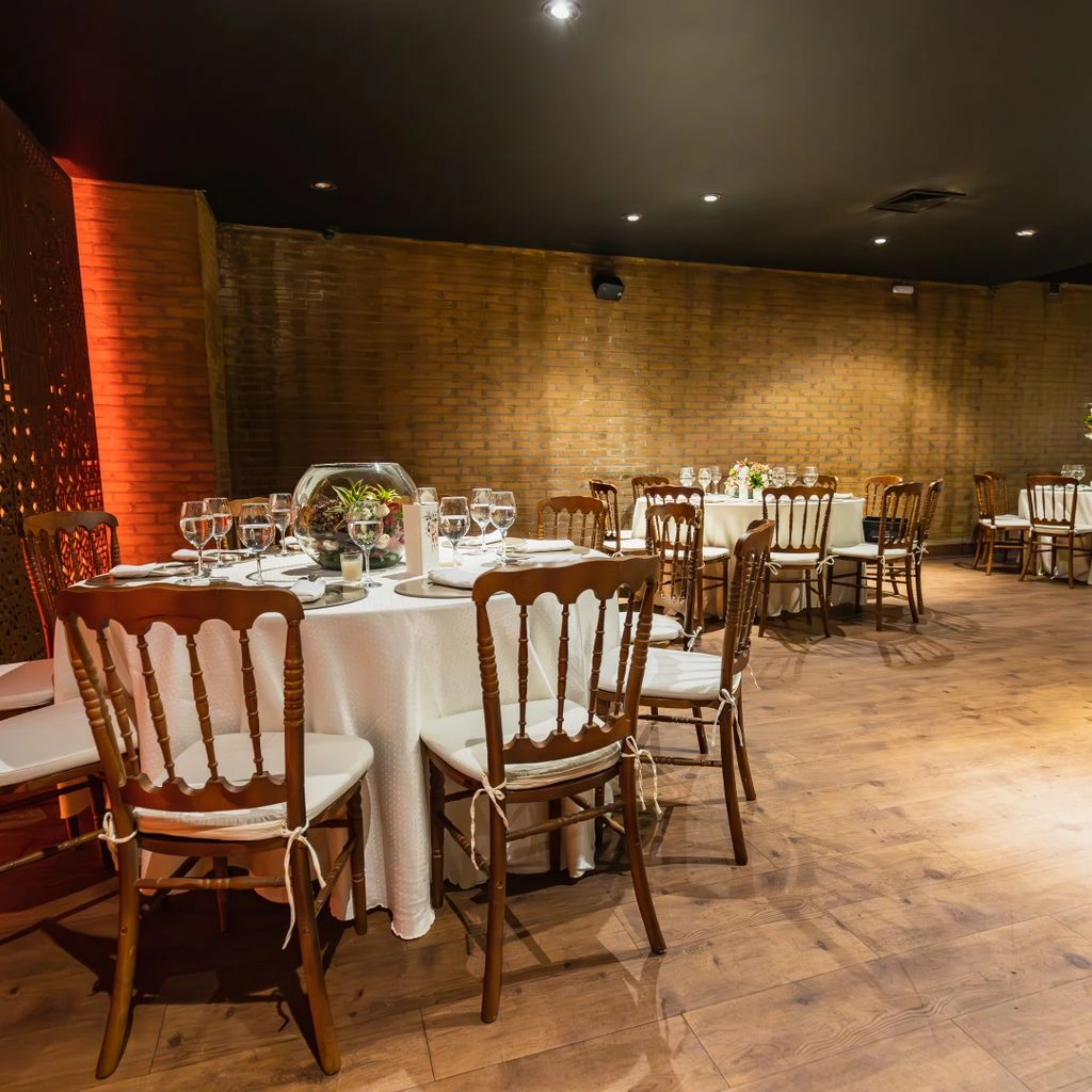 Long-table private banquet on the DNA Rock Cafe main floor with the stage lit in the background